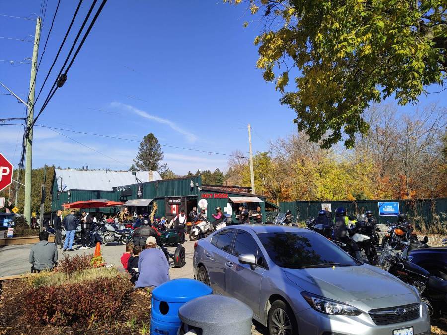 The parking lot at Higher Ground Cafe full of motorcycles and people.