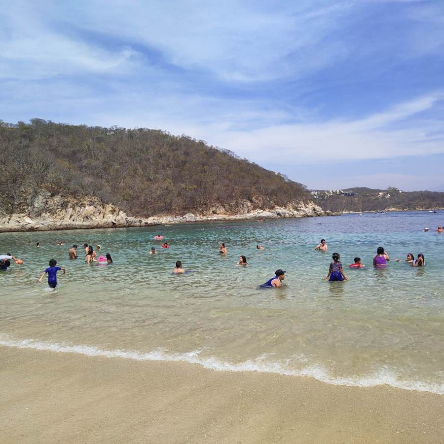 People swimming in the shallow waters of Playa La Entrega