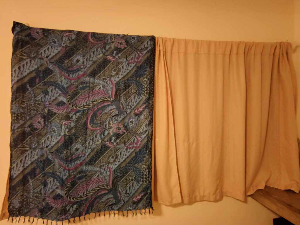 A sarong over a curtain to darken a room