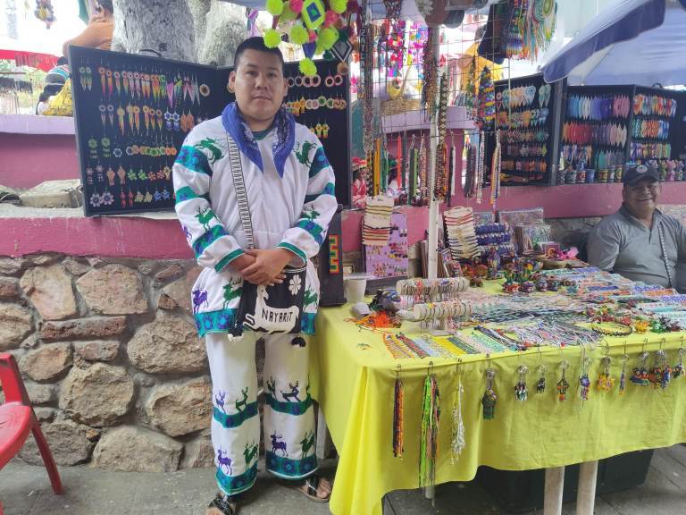 A Huichol person and his handmade art and souvenirs